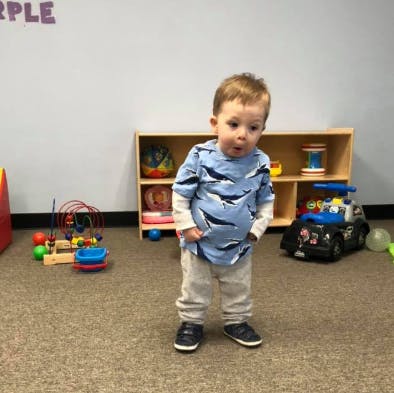 Toddler standing in a room with toys