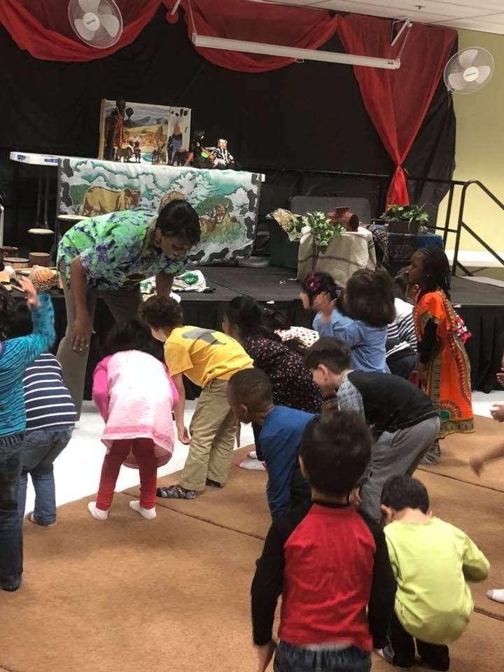 Adult interacting with children on a floor
