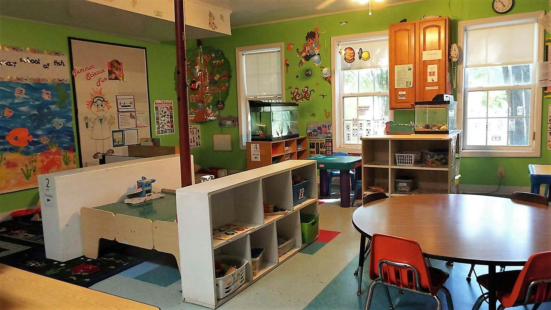 Classroom with tables, chairs, and shelves