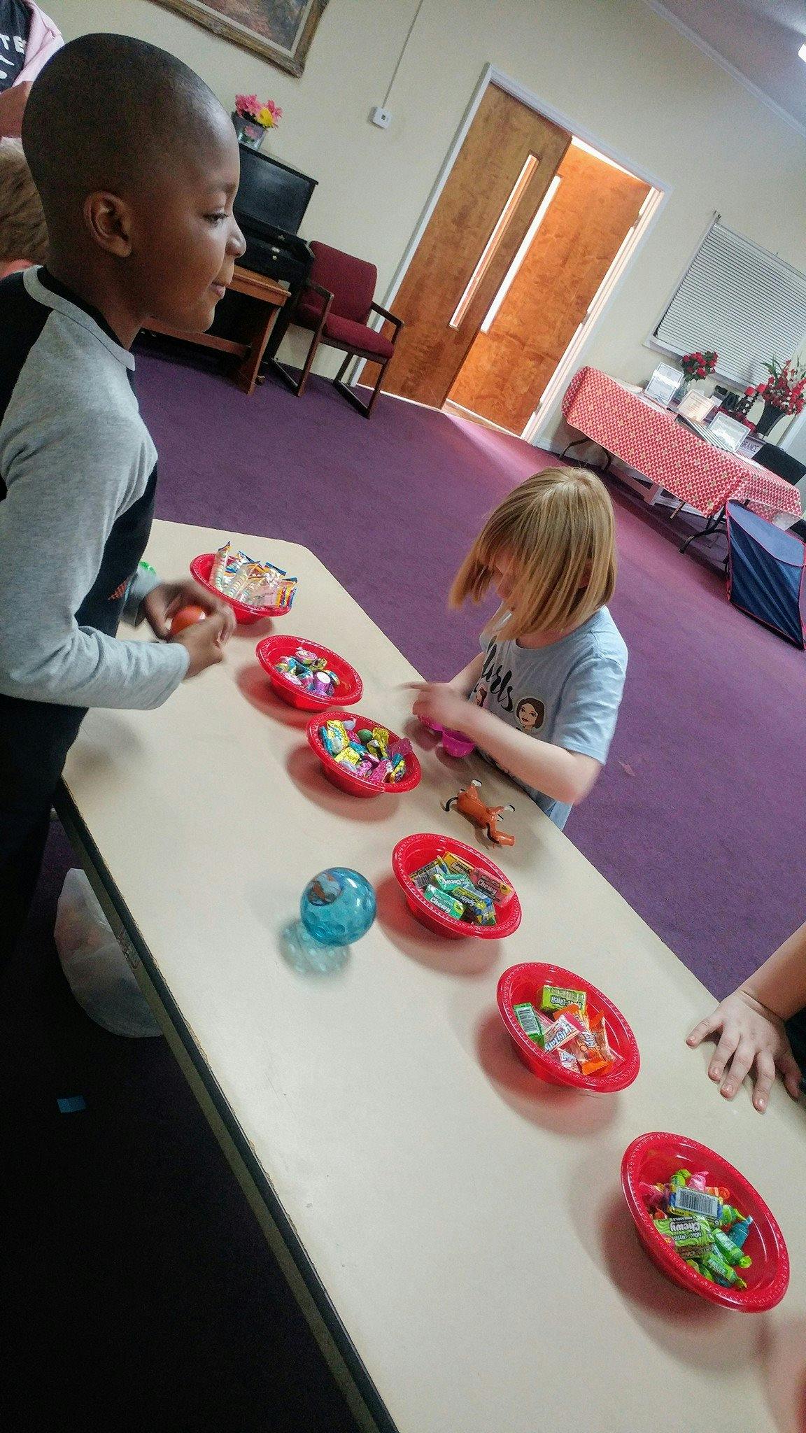 Two children at a table with bowls of candy