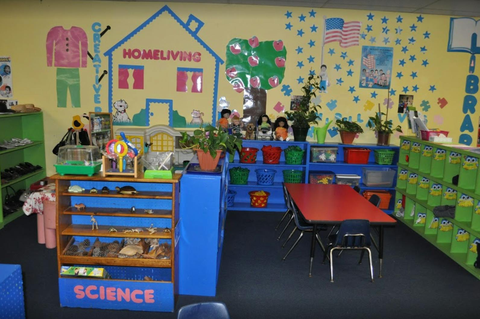 Classroom with a science shelf, red table, and wall decorations