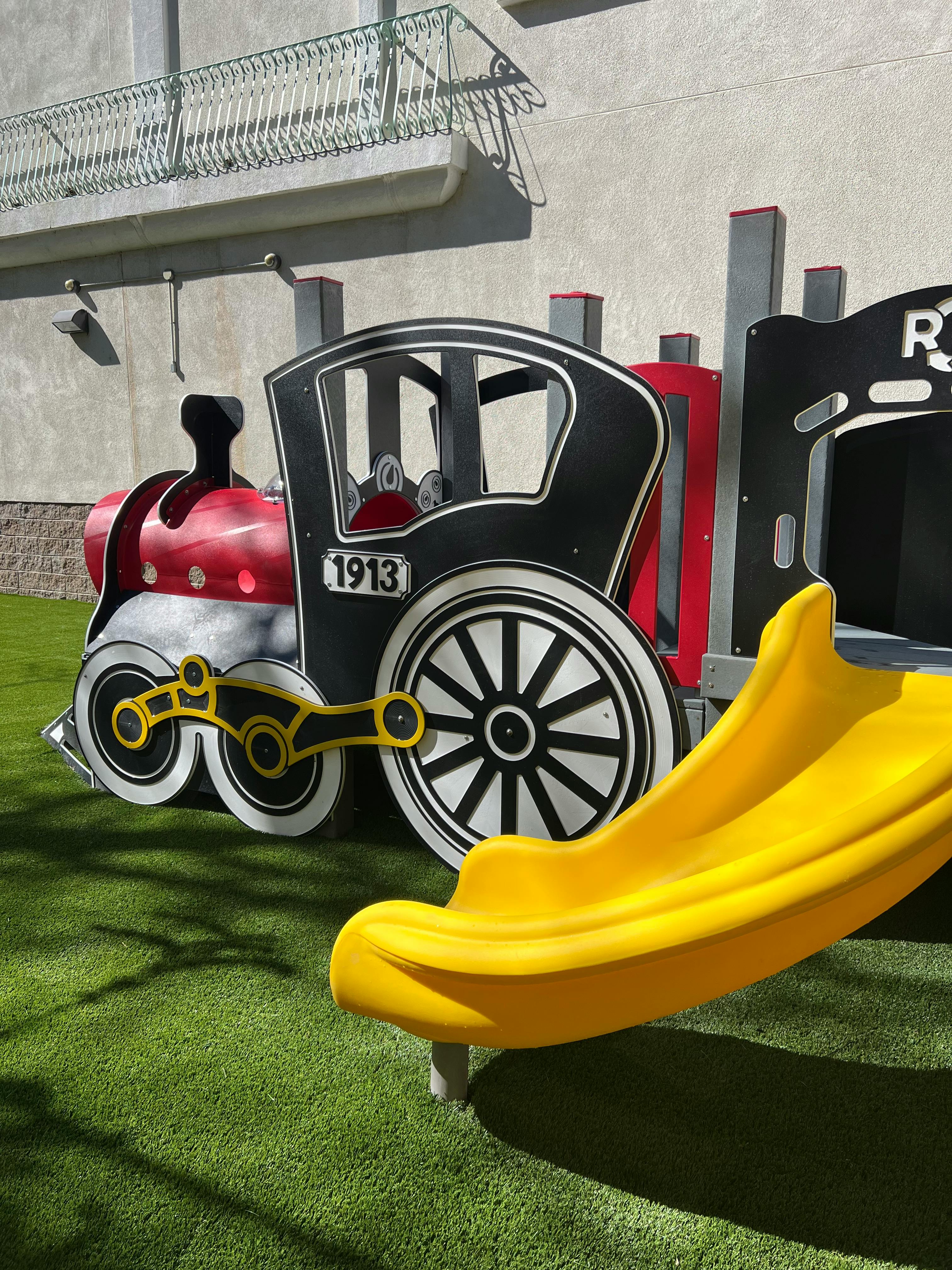 Train-shaped playground equipment with a yellow slide