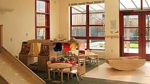 Playroom with slide, small table and chairs, and large windows