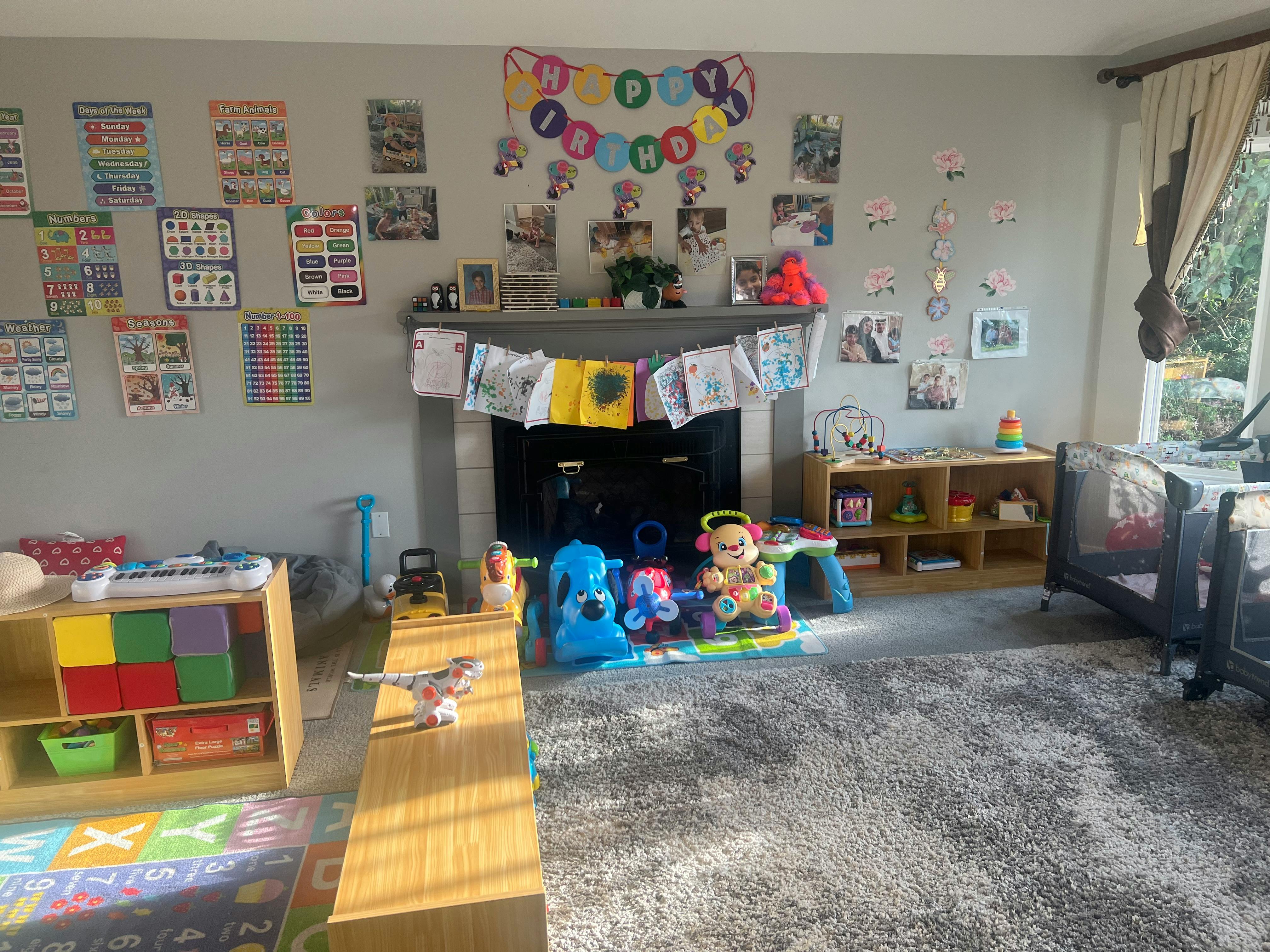 Child's playroom with toys, cribs, and decorations on the wall