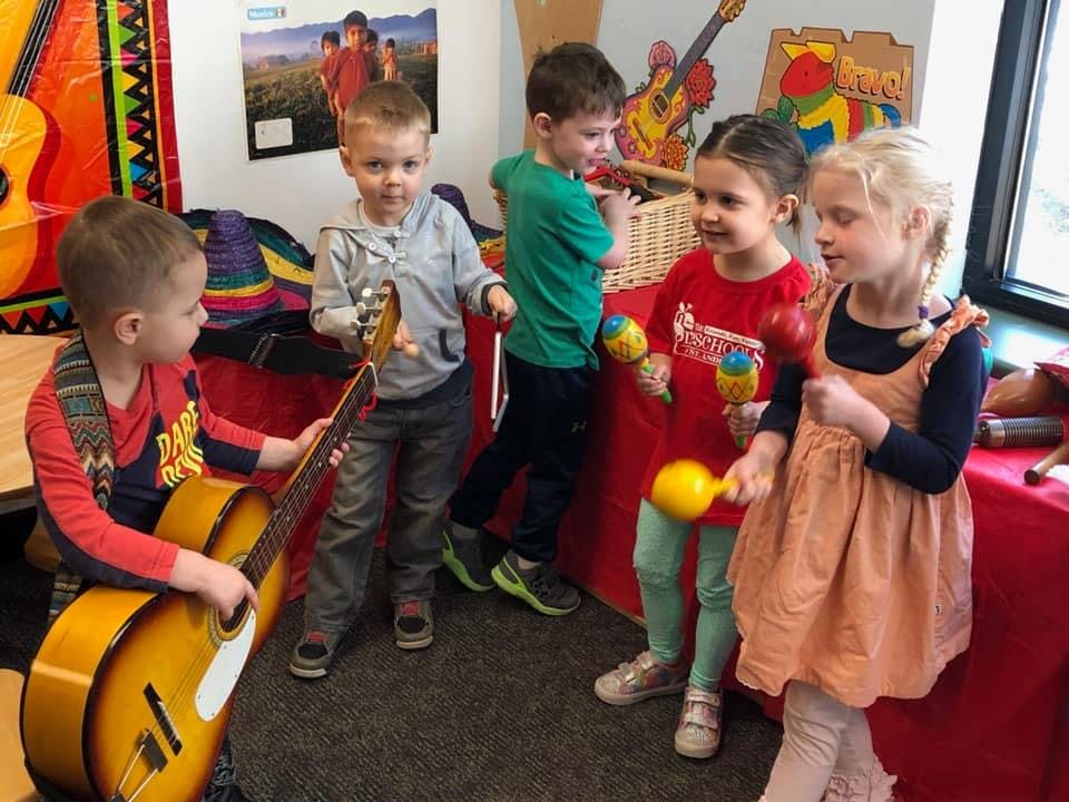 Children playing with musical instruments in a classroom