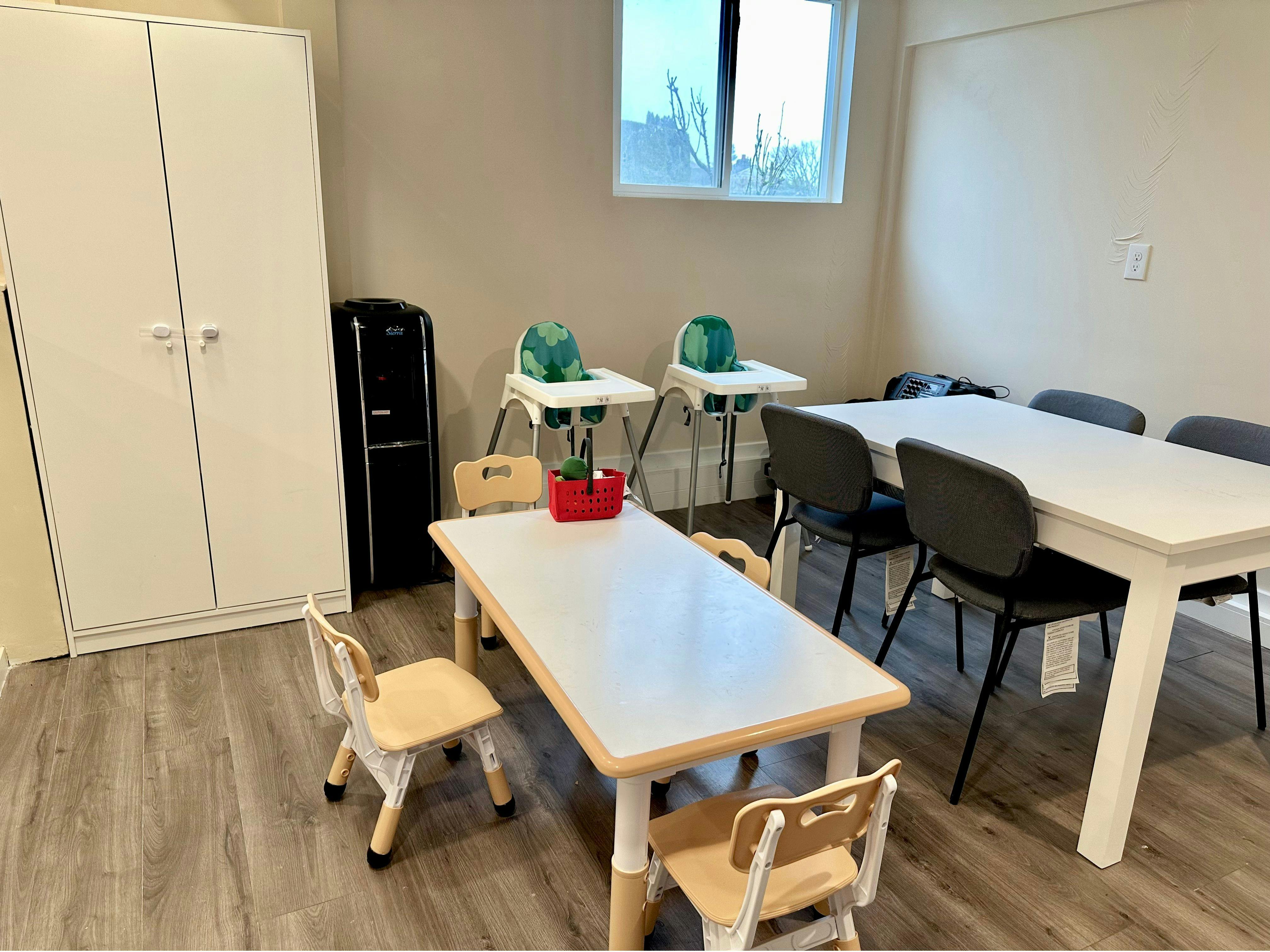 Room with child-sized tables and chairs, high chairs, and adult-sized tables and chairs