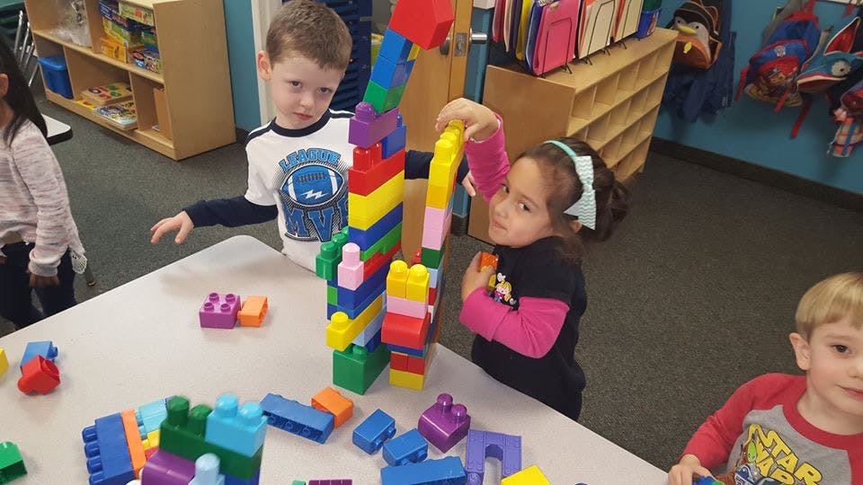 Children playing with colorful building blocks at a table