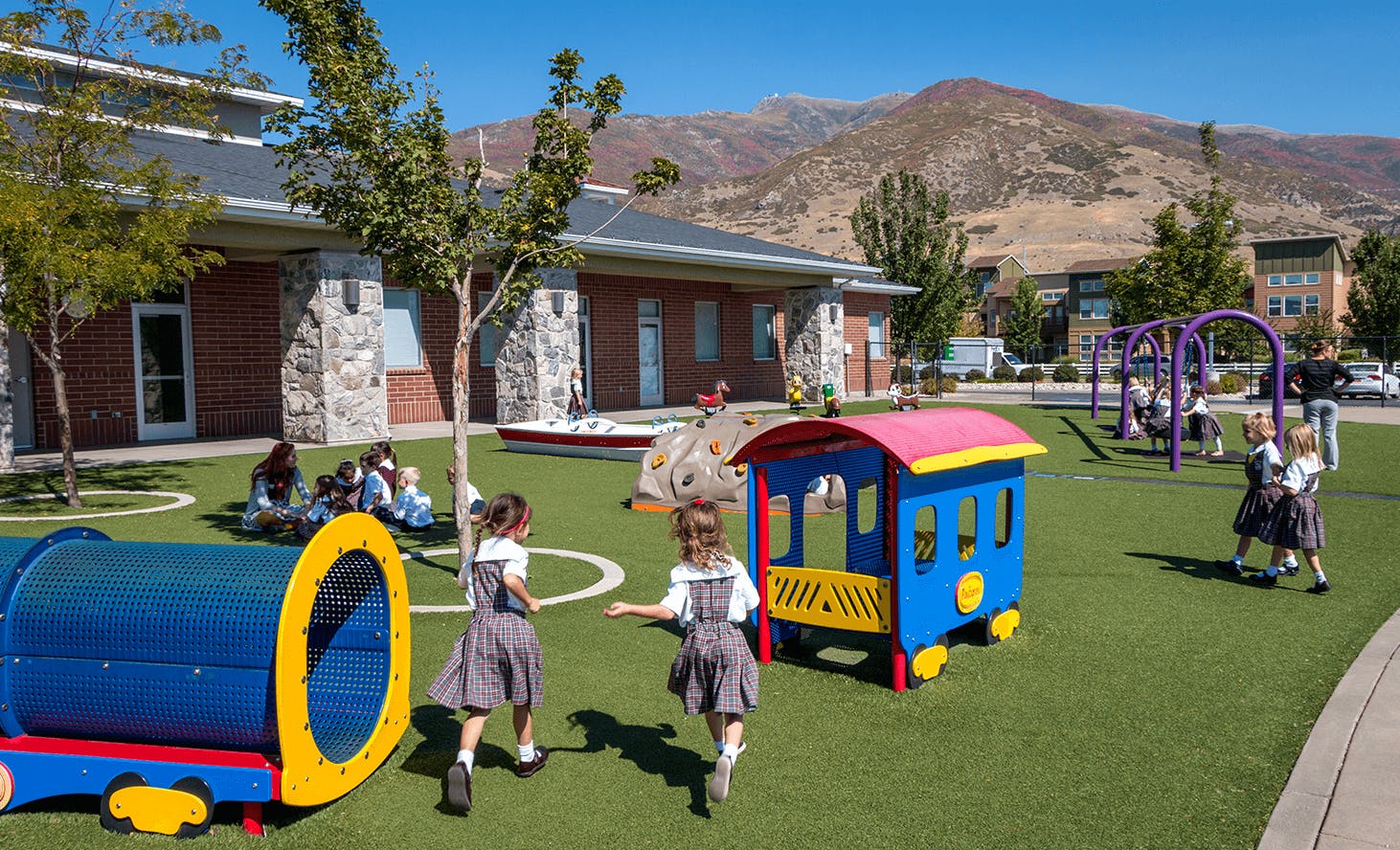 Children playing on a playground with train-shaped play structures