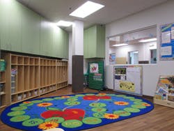 Empty classroom with cubbies and a colorful rug