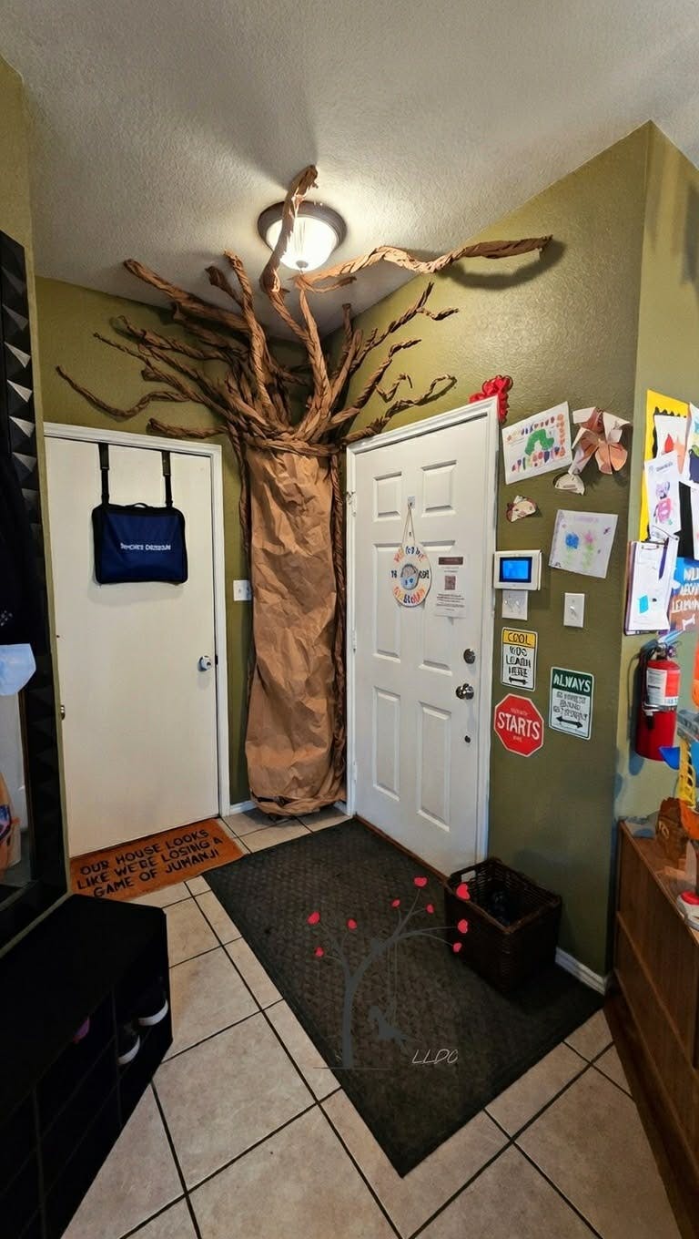Decorative paper tree with branches on a wall between two white doors