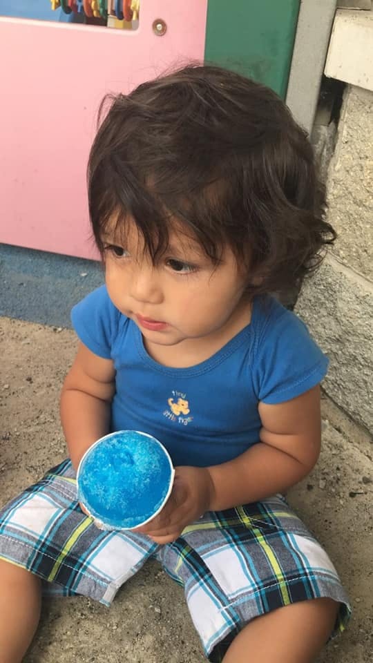 Child holding a cup of blue shaved ice