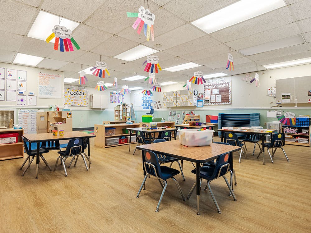Empty classroom with small tables and chairs, and colorful decorations