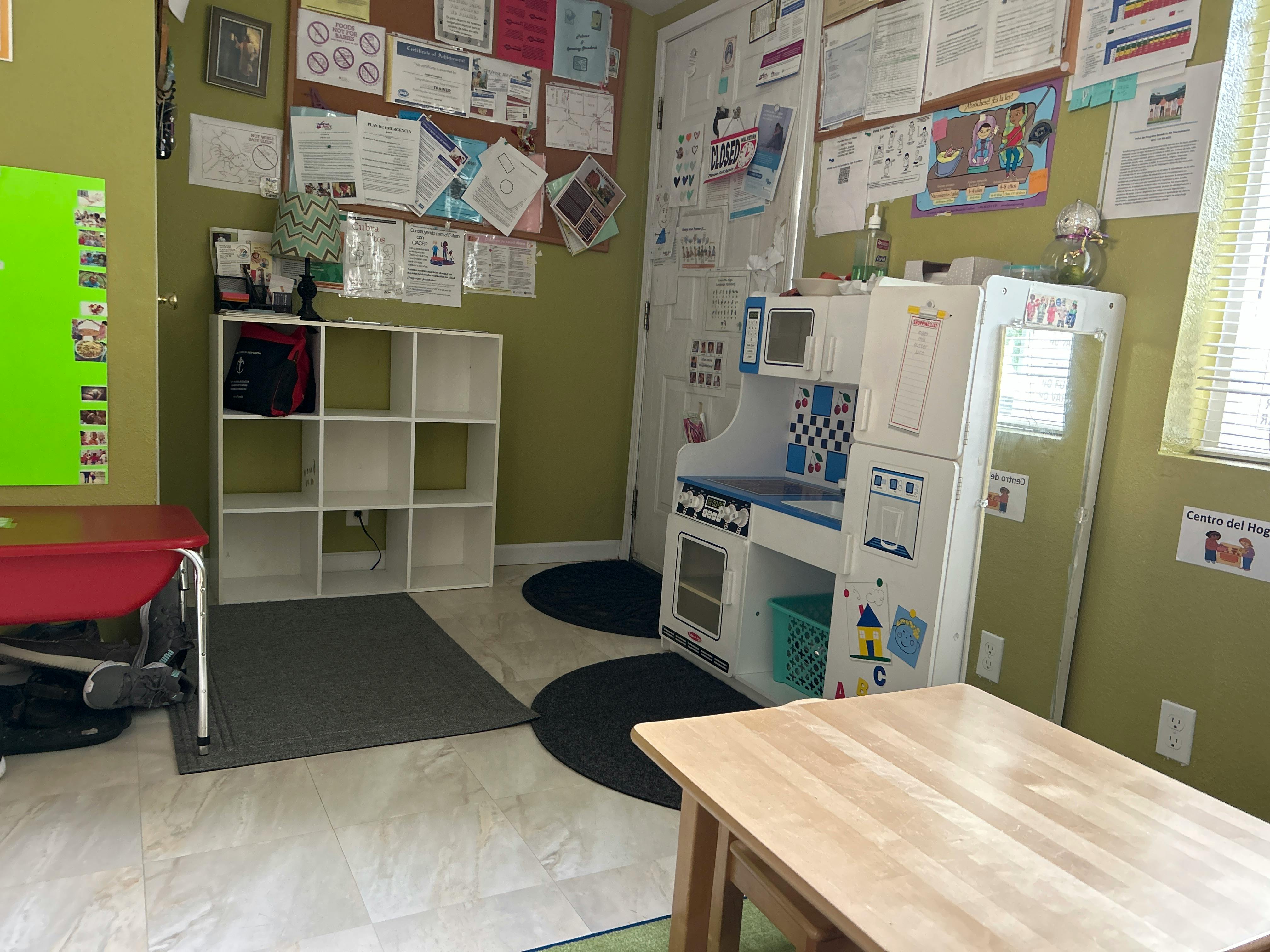 Playroom with toy kitchen, storage cubbies, and tables