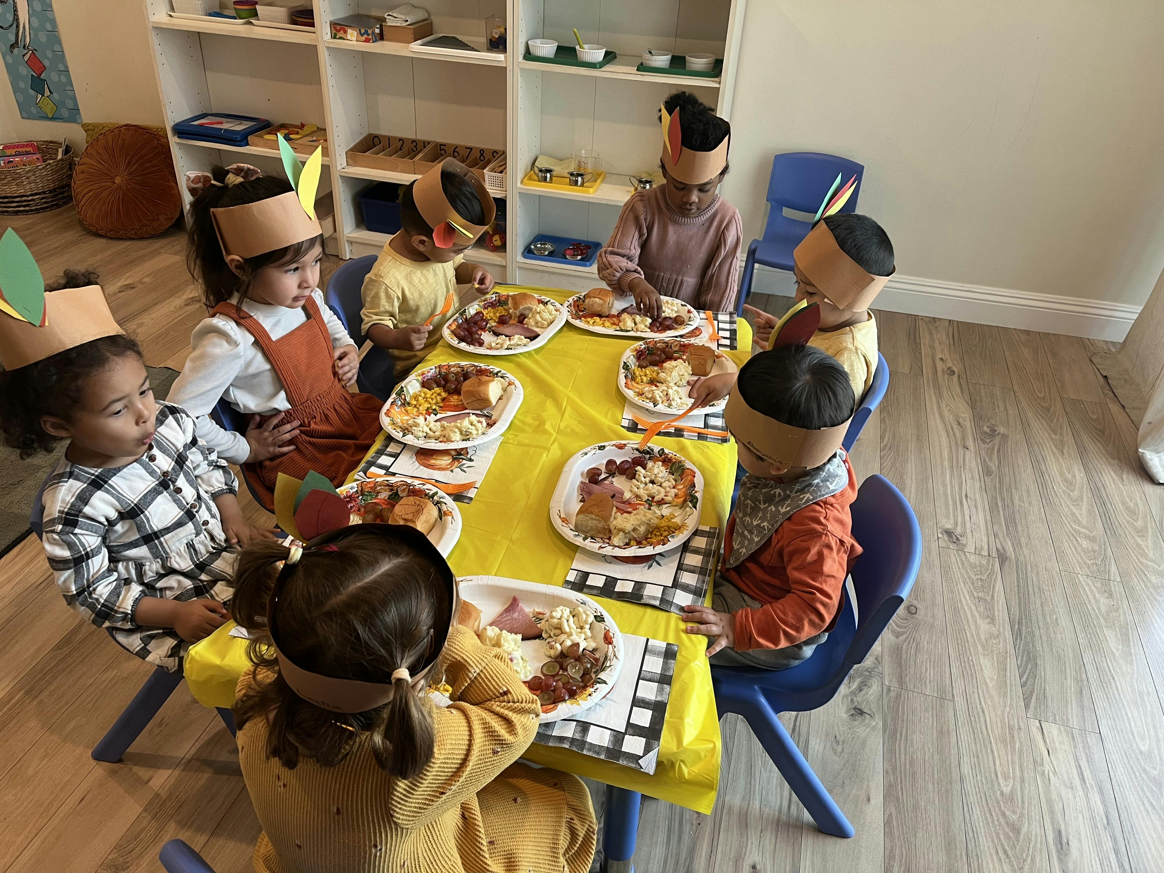 Children sitting around a table with plates of food