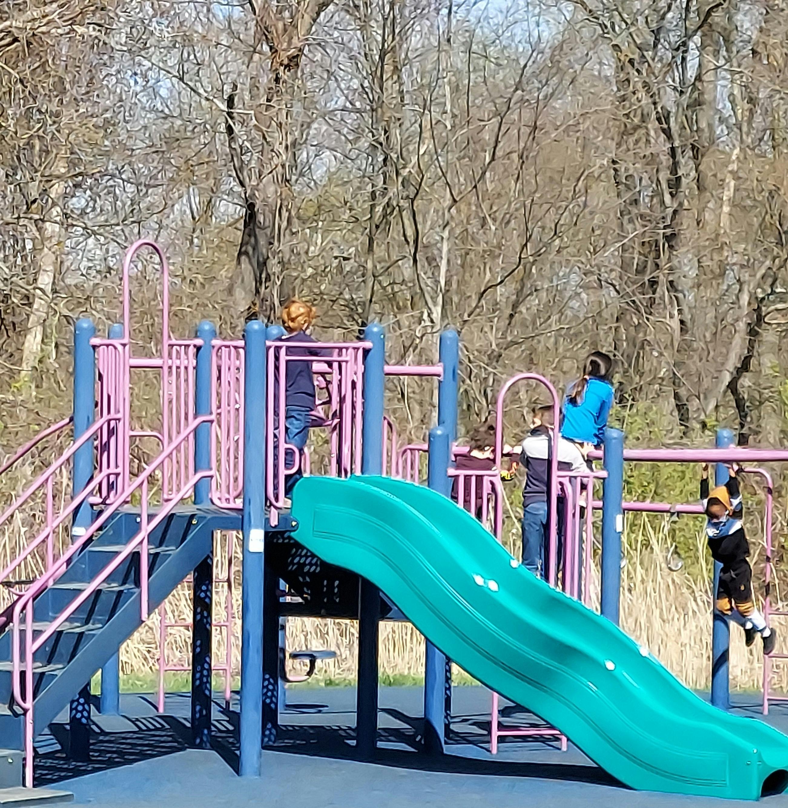 Children playing on a playground structure with a slide