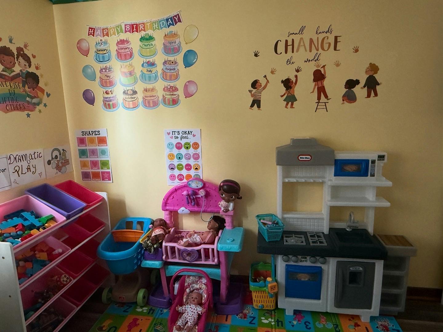 Playroom with toy kitchen, doll cribs, and toy storage shelves