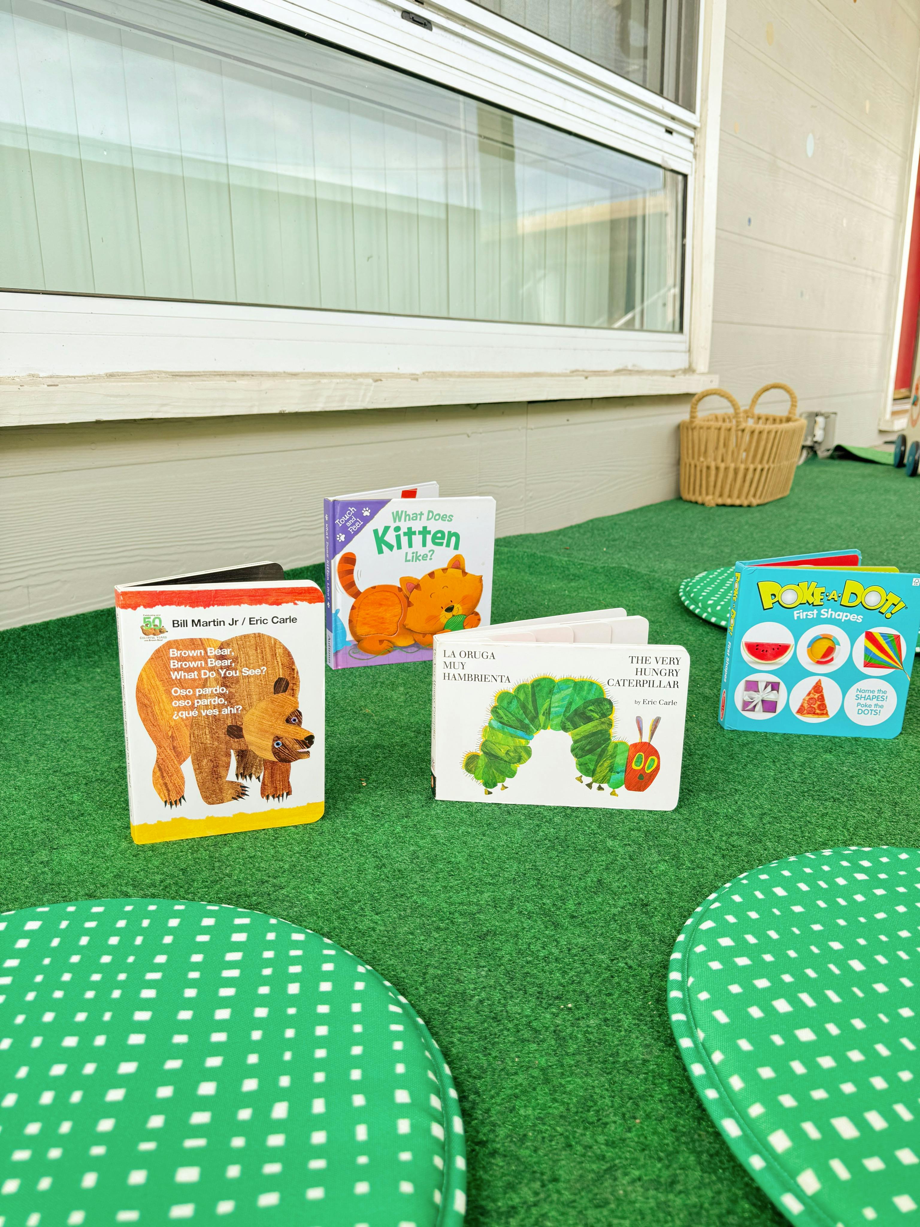 Children's books on a green carpet