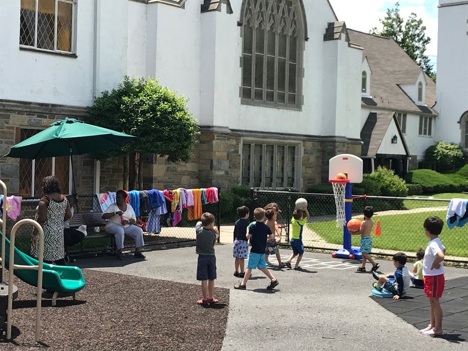 Children playing basketball and on a slide outdoors