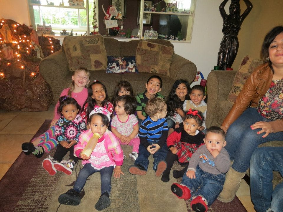 Group of children and adults sitting on a rug in a living room