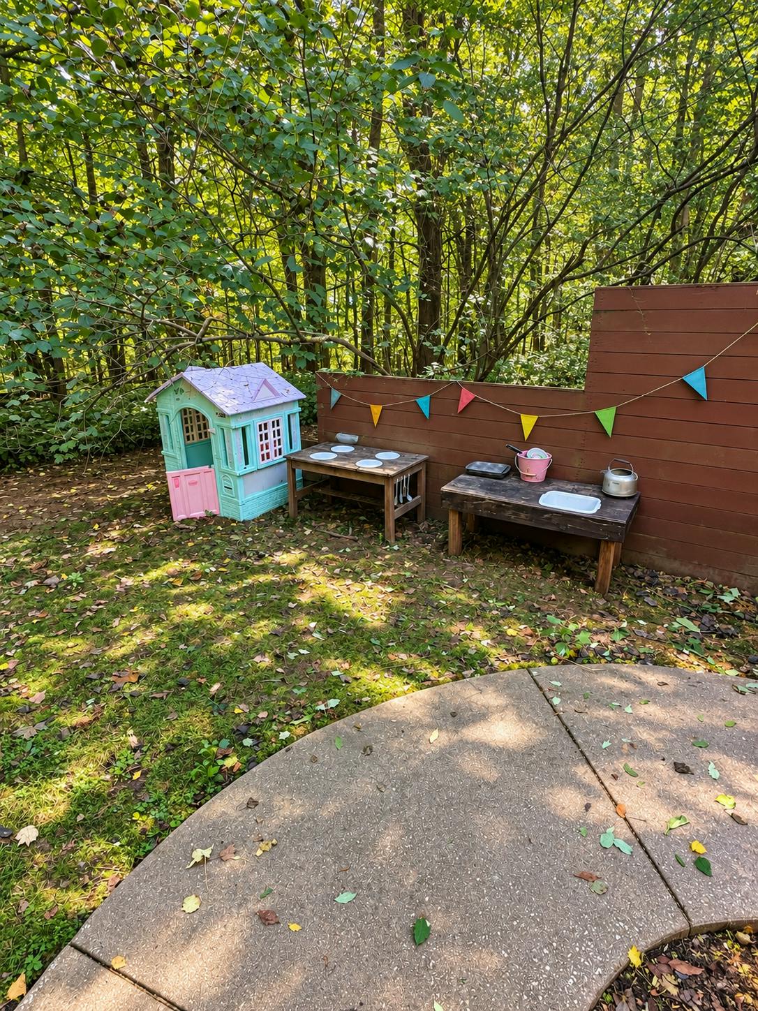 Playhouse and outdoor mud kitchen in a wooded garden area