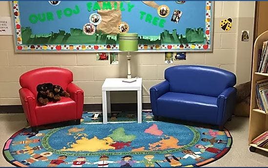 Children's seating area with red chair, blue couch, and world map rug