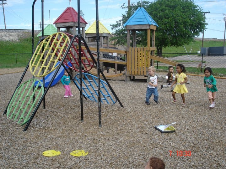 Children playing on a playground with climbing structures