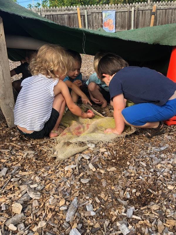 Children playing under a makeshift tent