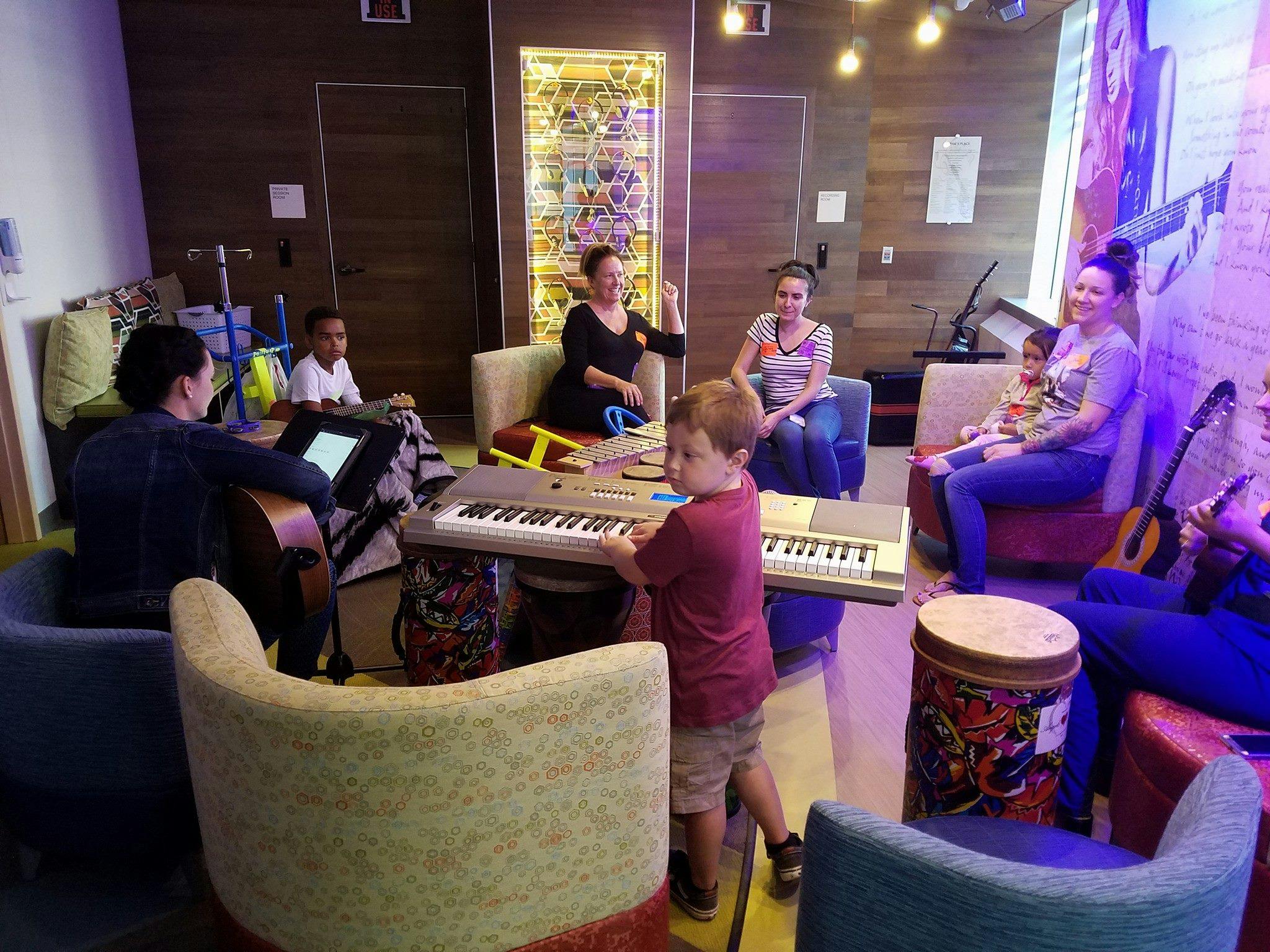 People and children gathered in a room with musical instruments