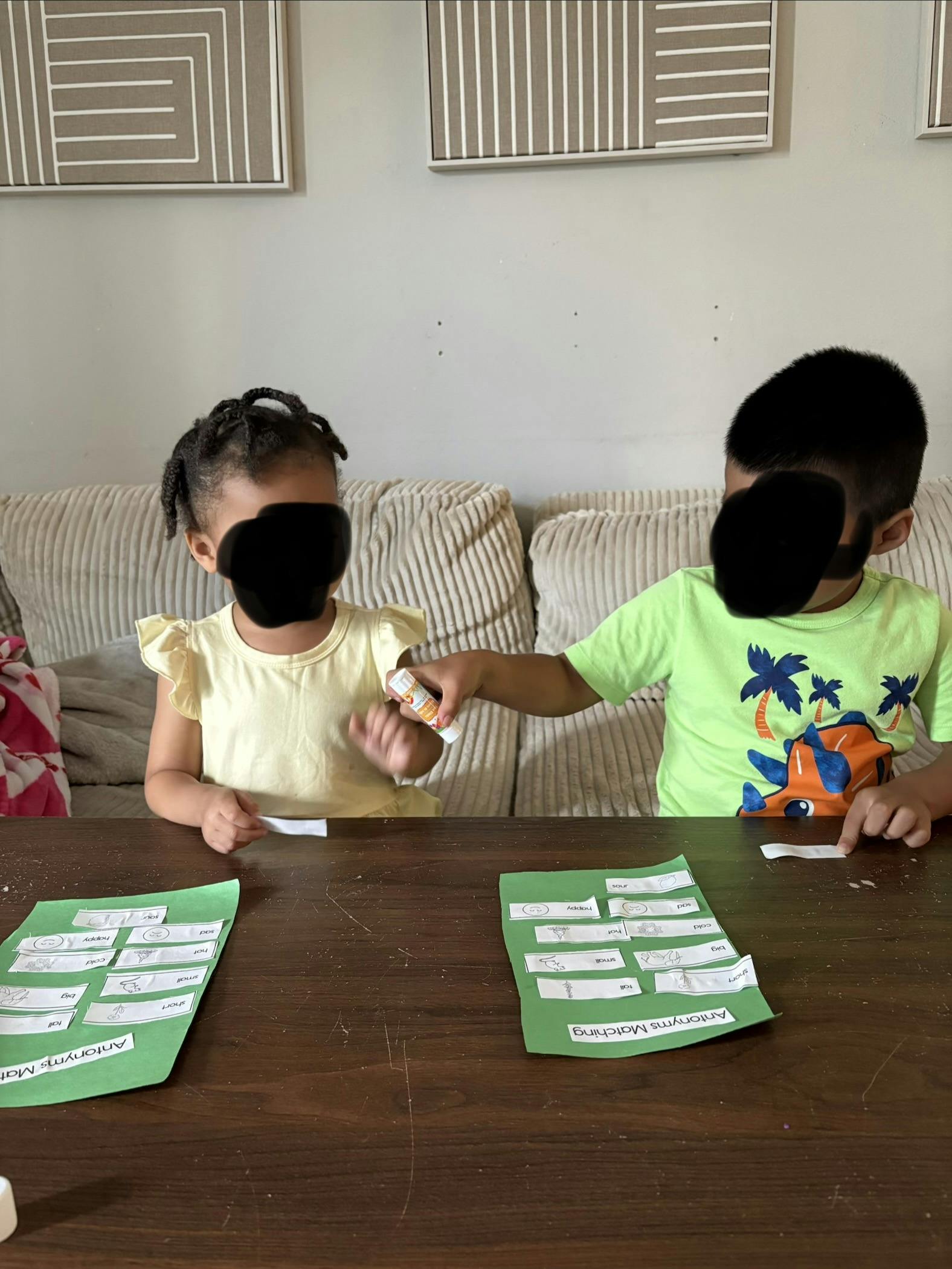 Two children working on an antonyms matching worksheet at a table