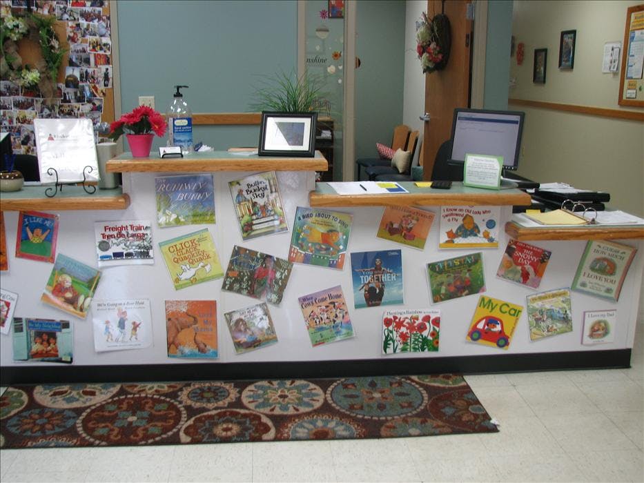Reception desk with numerous children's books displayed on the front