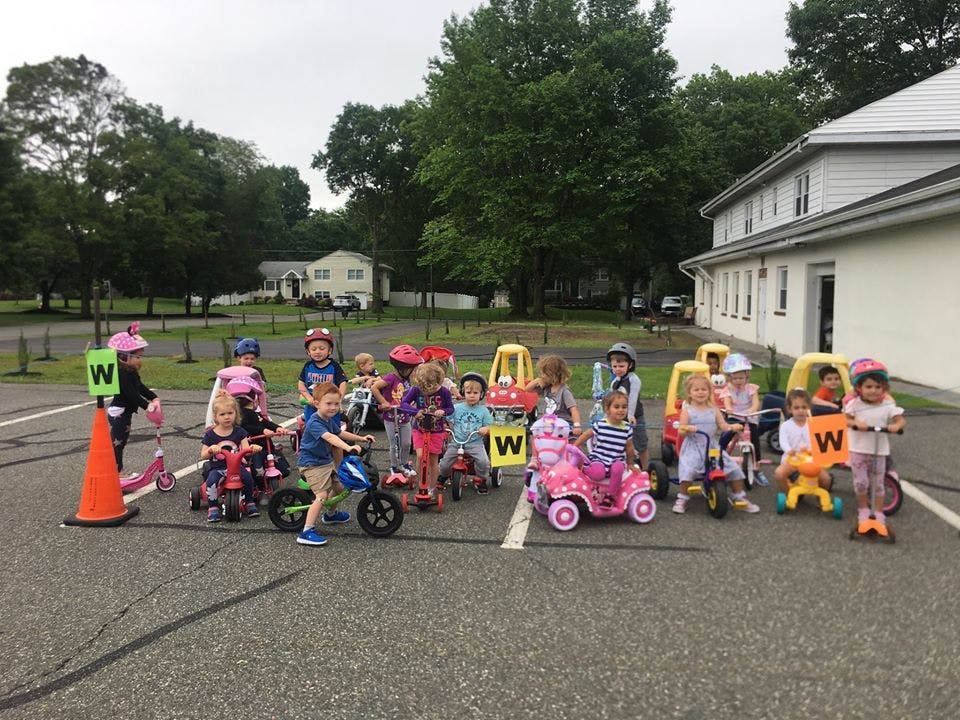 Group of children on bikes and scooters with traffic cones