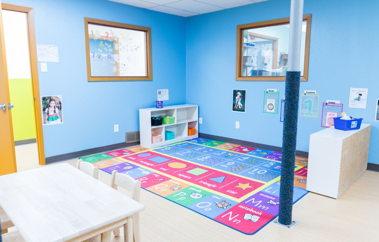 Colorful educational rug with letters and shapes in a preschool classroom