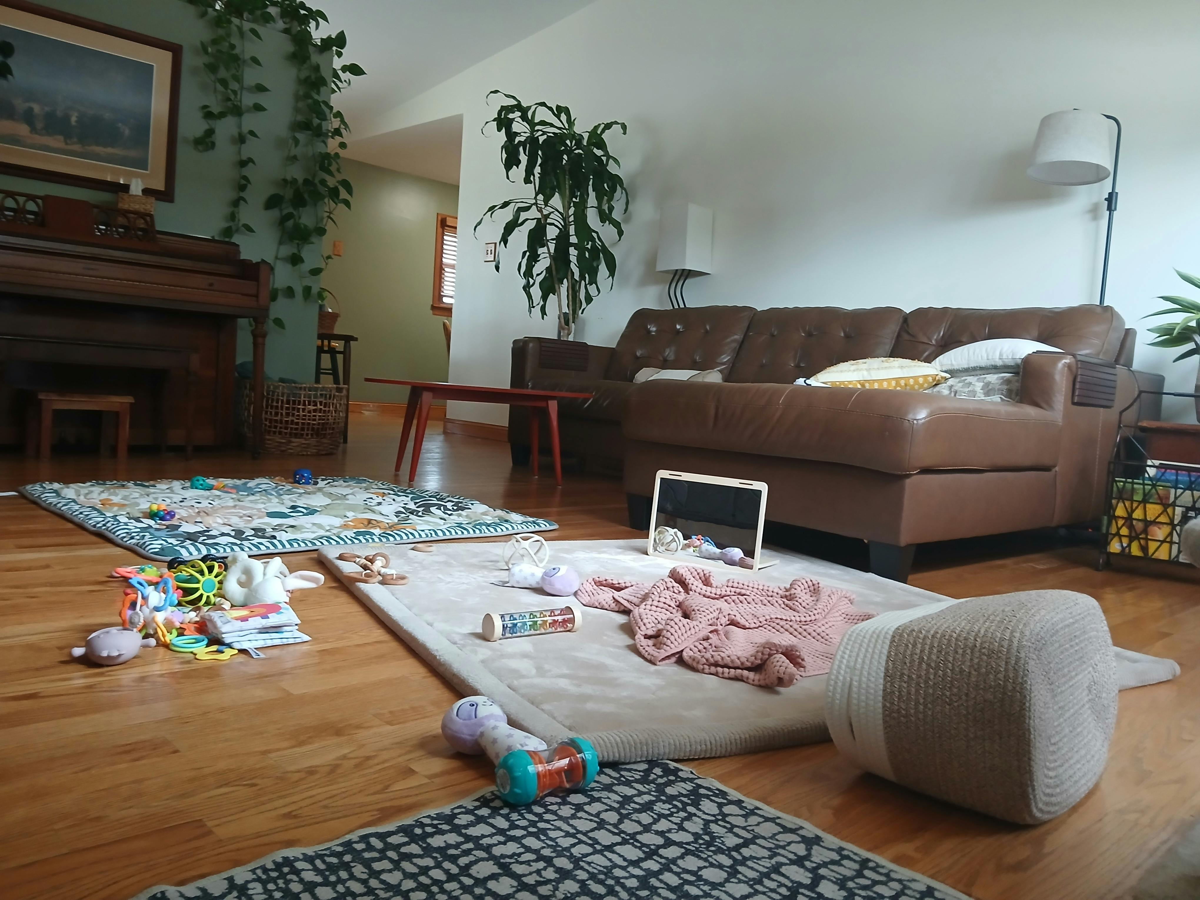 Baby toys scattered on play mats in a living room