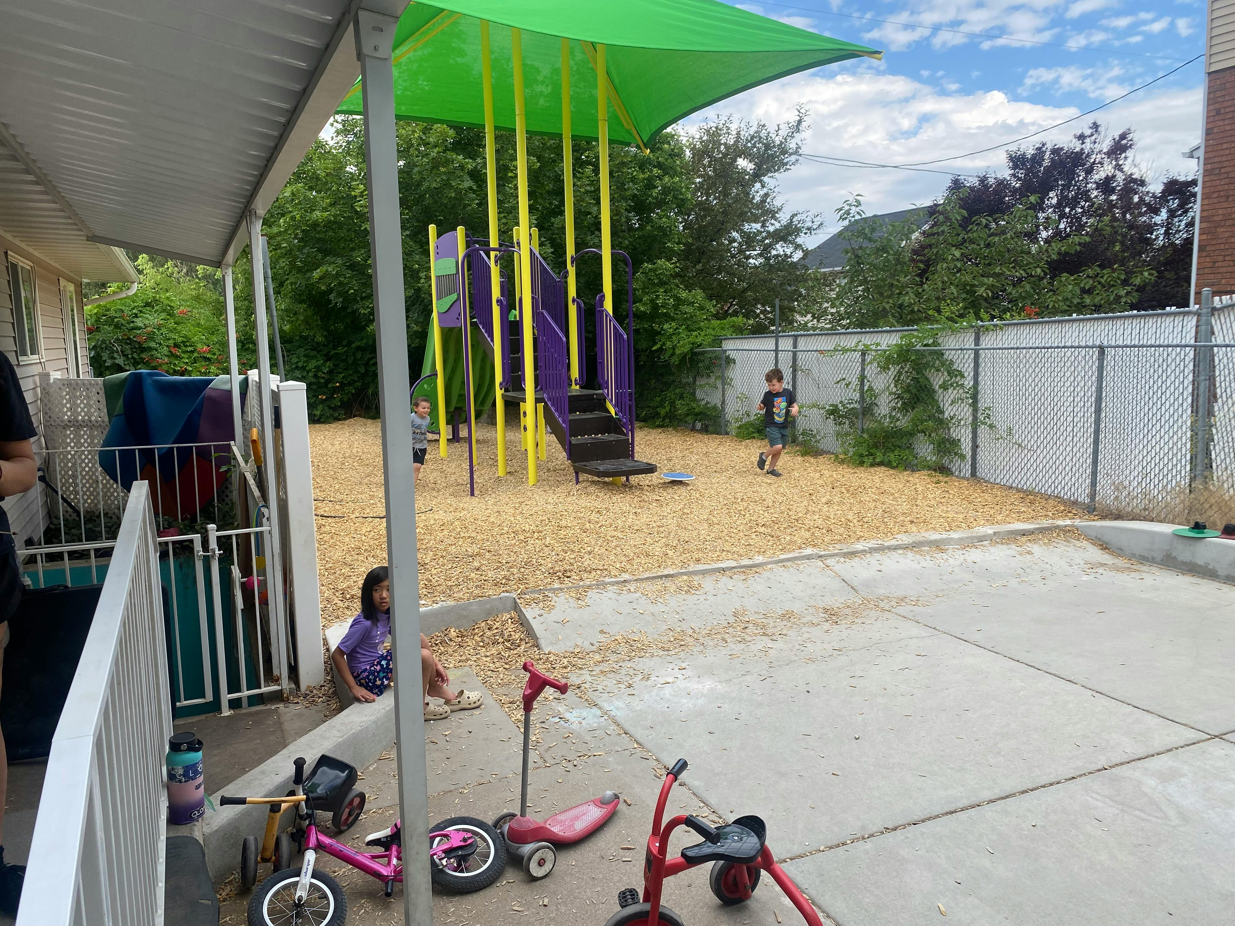 Children on a playground with a slide and play structure