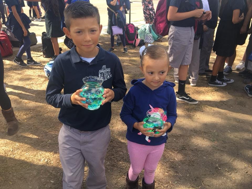 Two children holding decorated jars