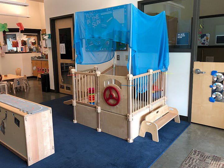 Play structure with blue canopy in a classroom