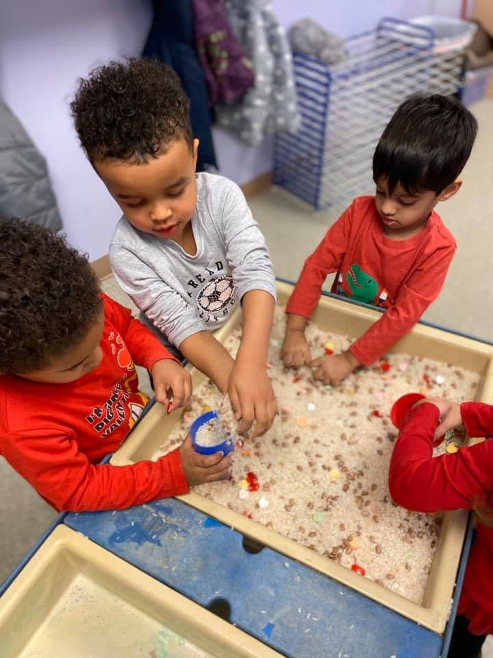 Children playing with sensory bin in a classroom