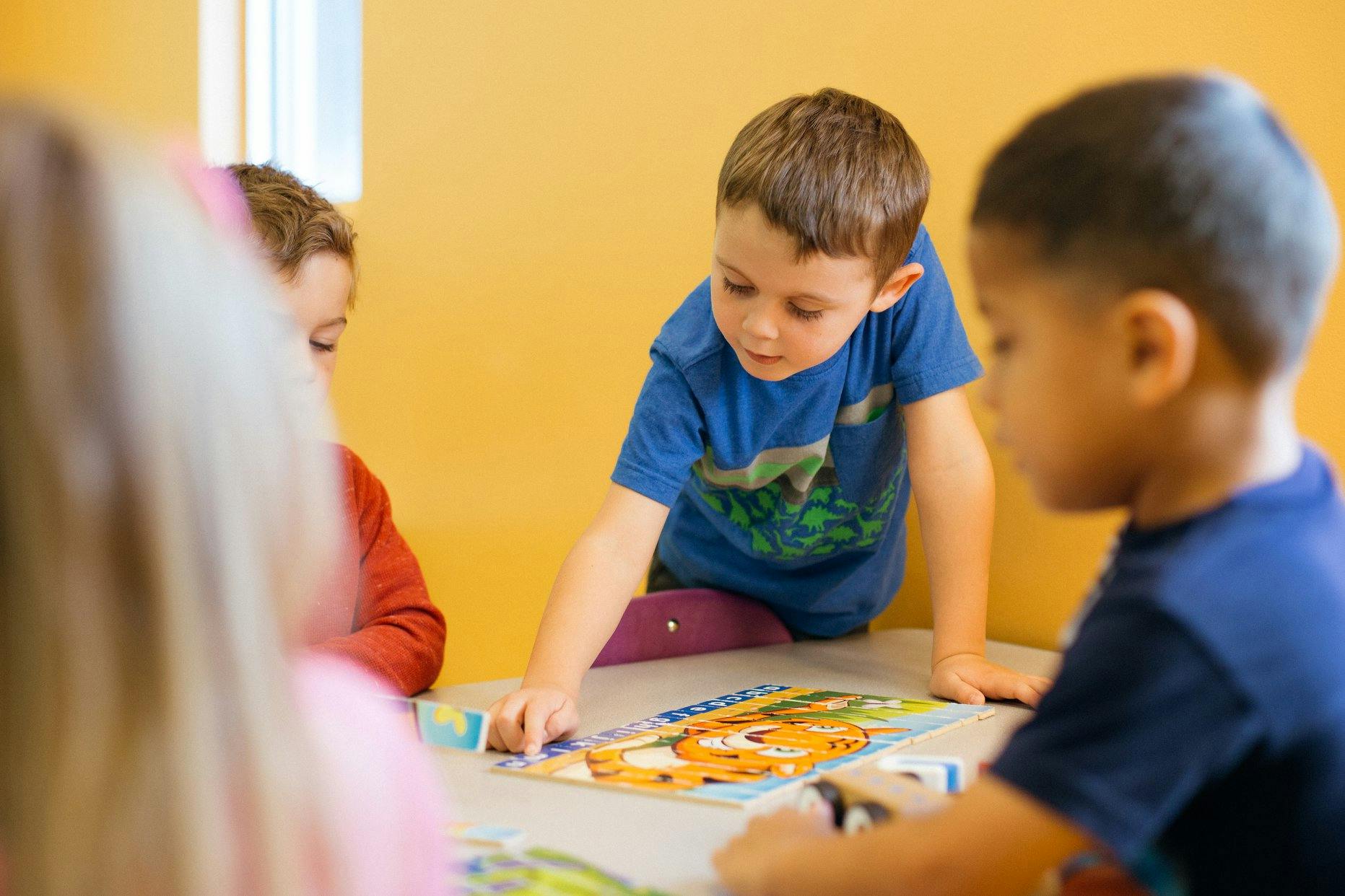 Children playing with a puzzle at a table