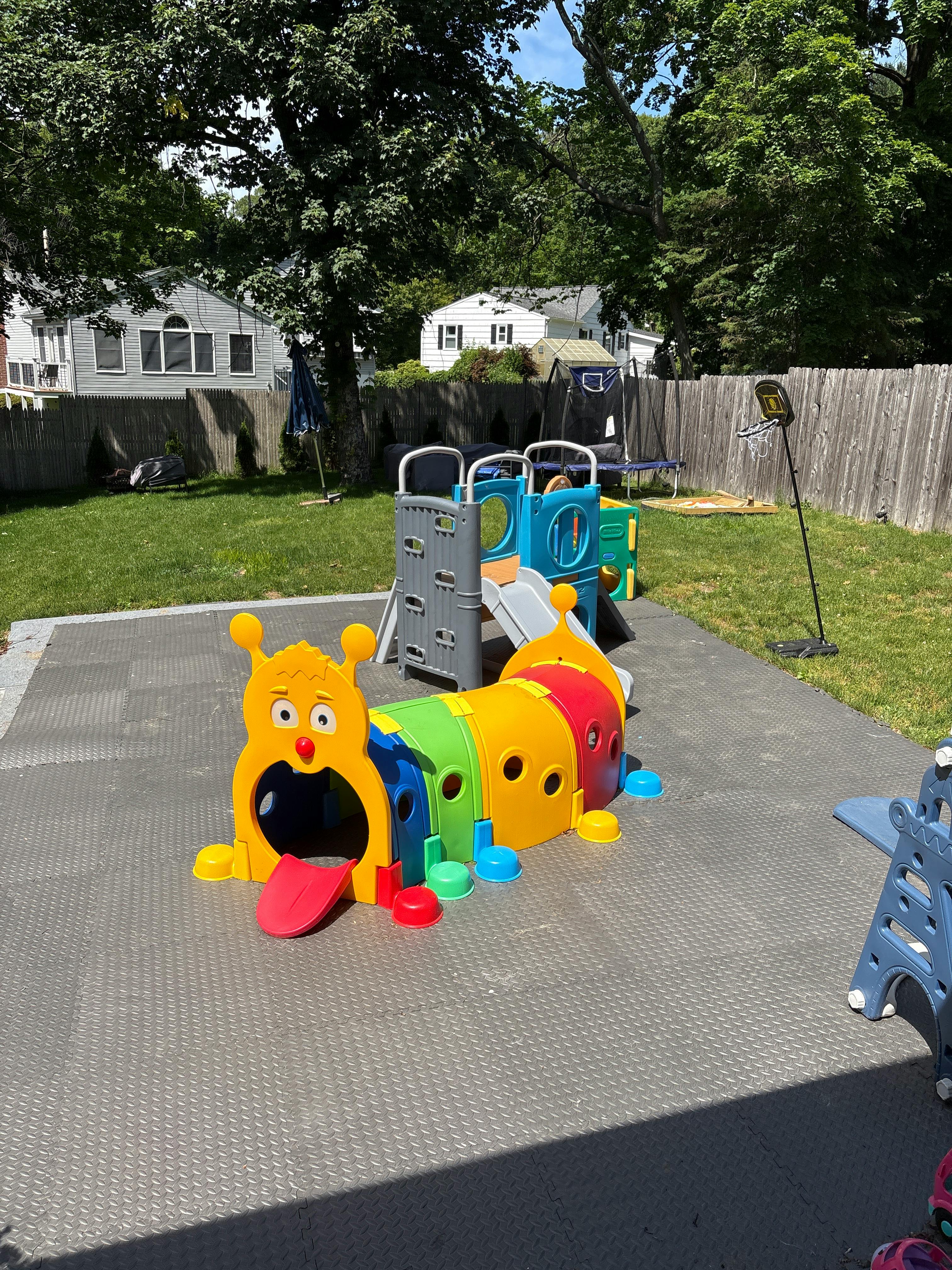 Colorful caterpillar tunnel and playground slide in a backyard