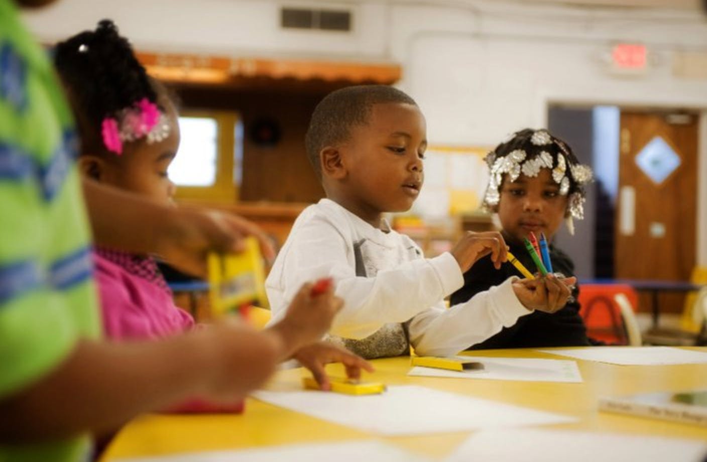 Children drawing at a table in a classroom