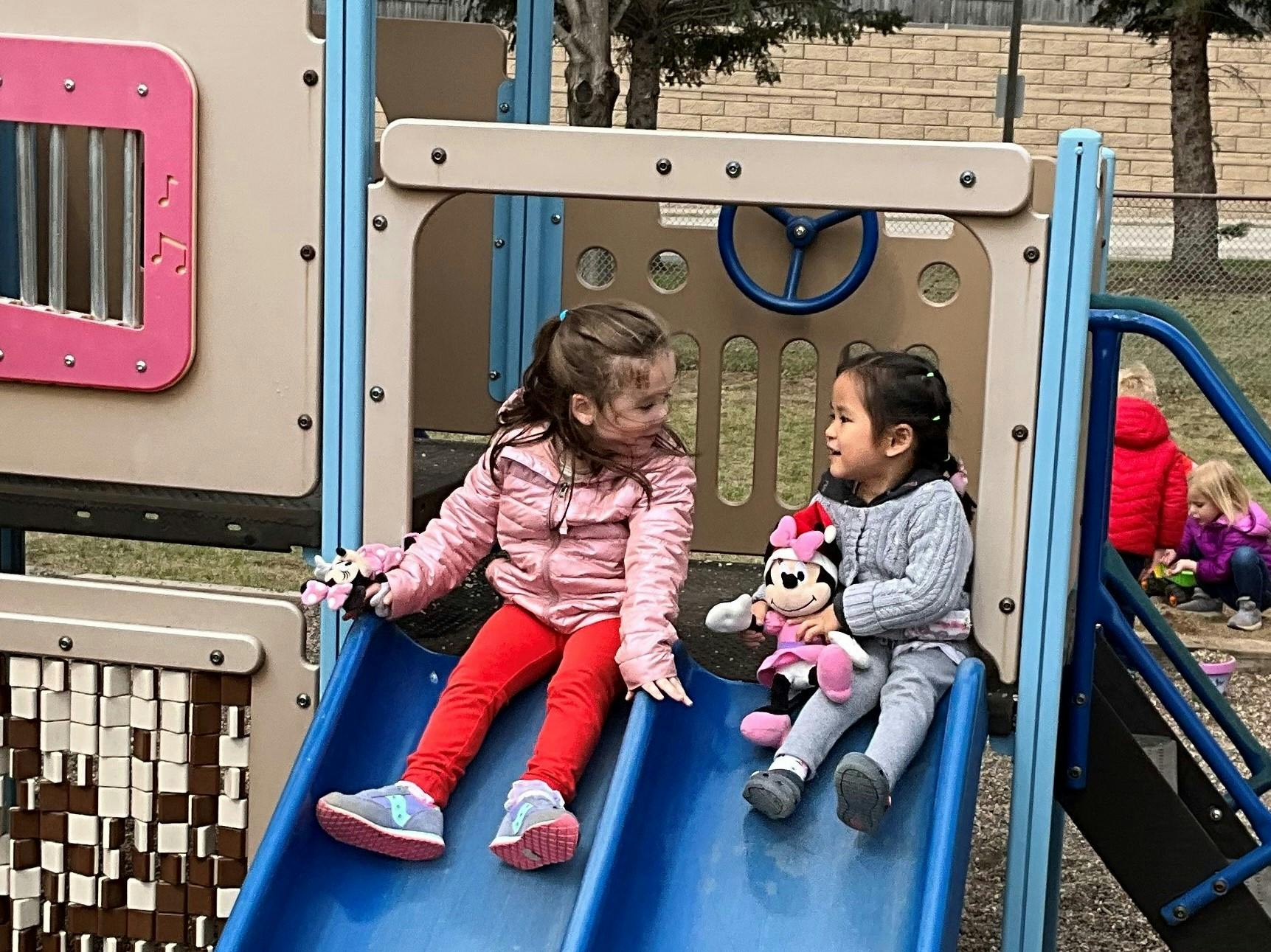 Two children sitting on a playground slide