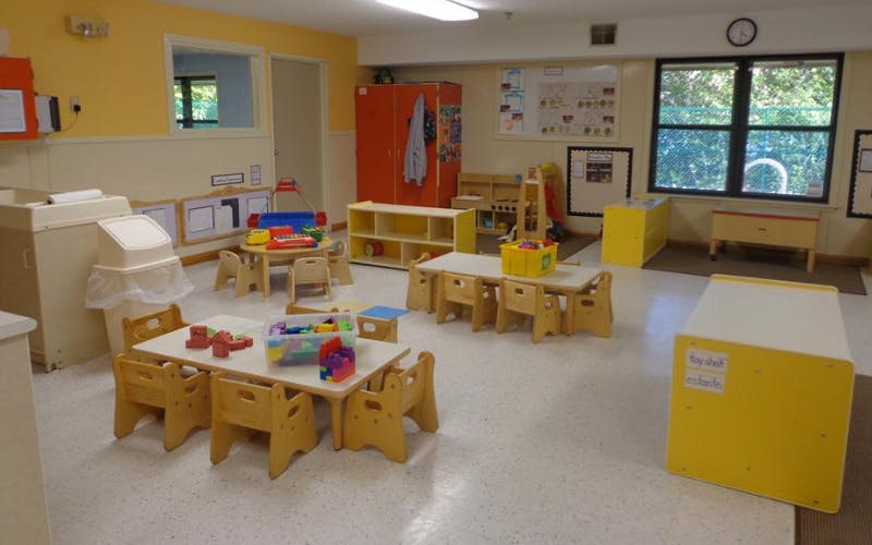 Classroom with child-sized tables and chairs and various colorful toys