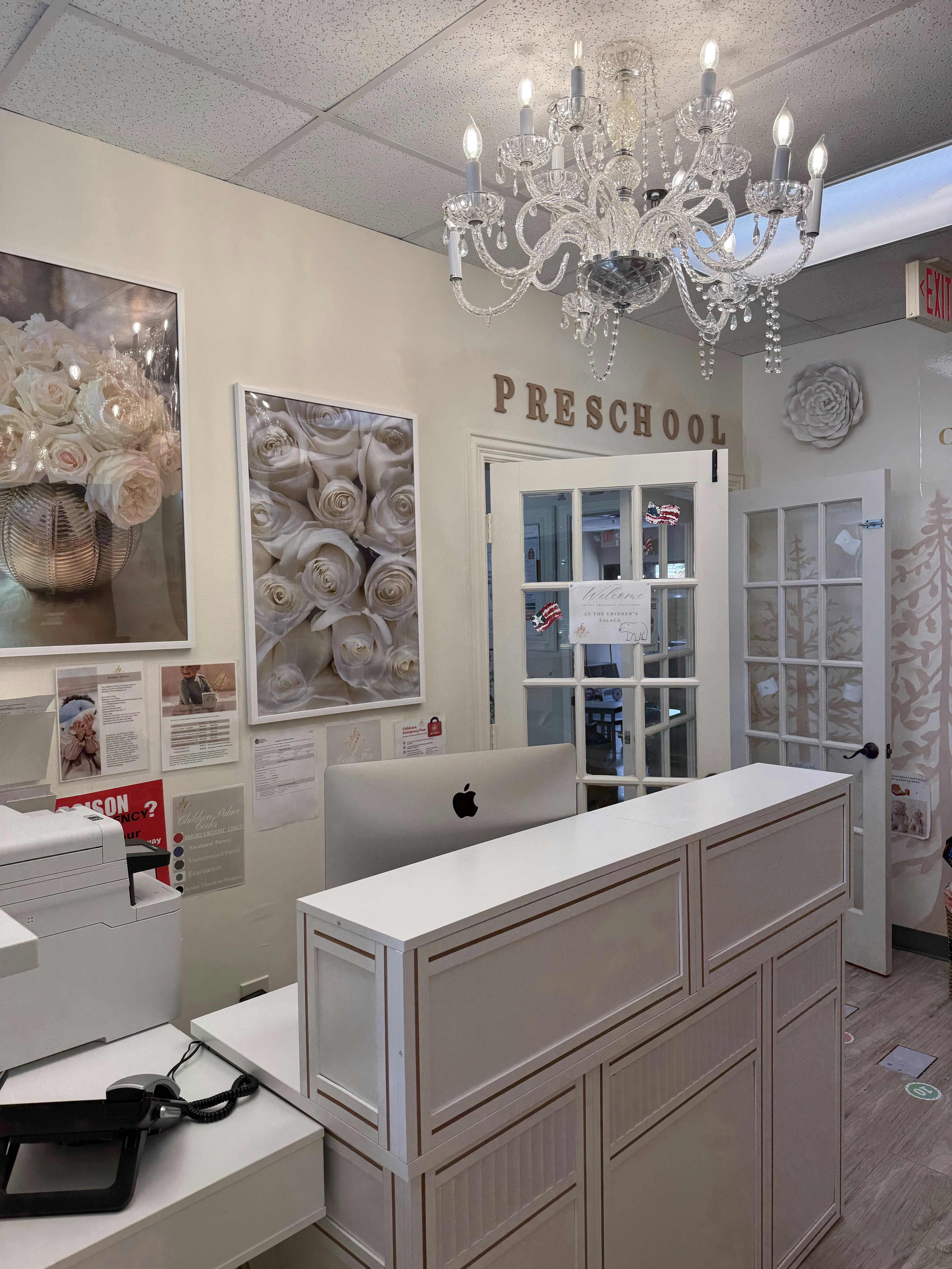 Reception desk and front entrance to a preschool with a chandelier