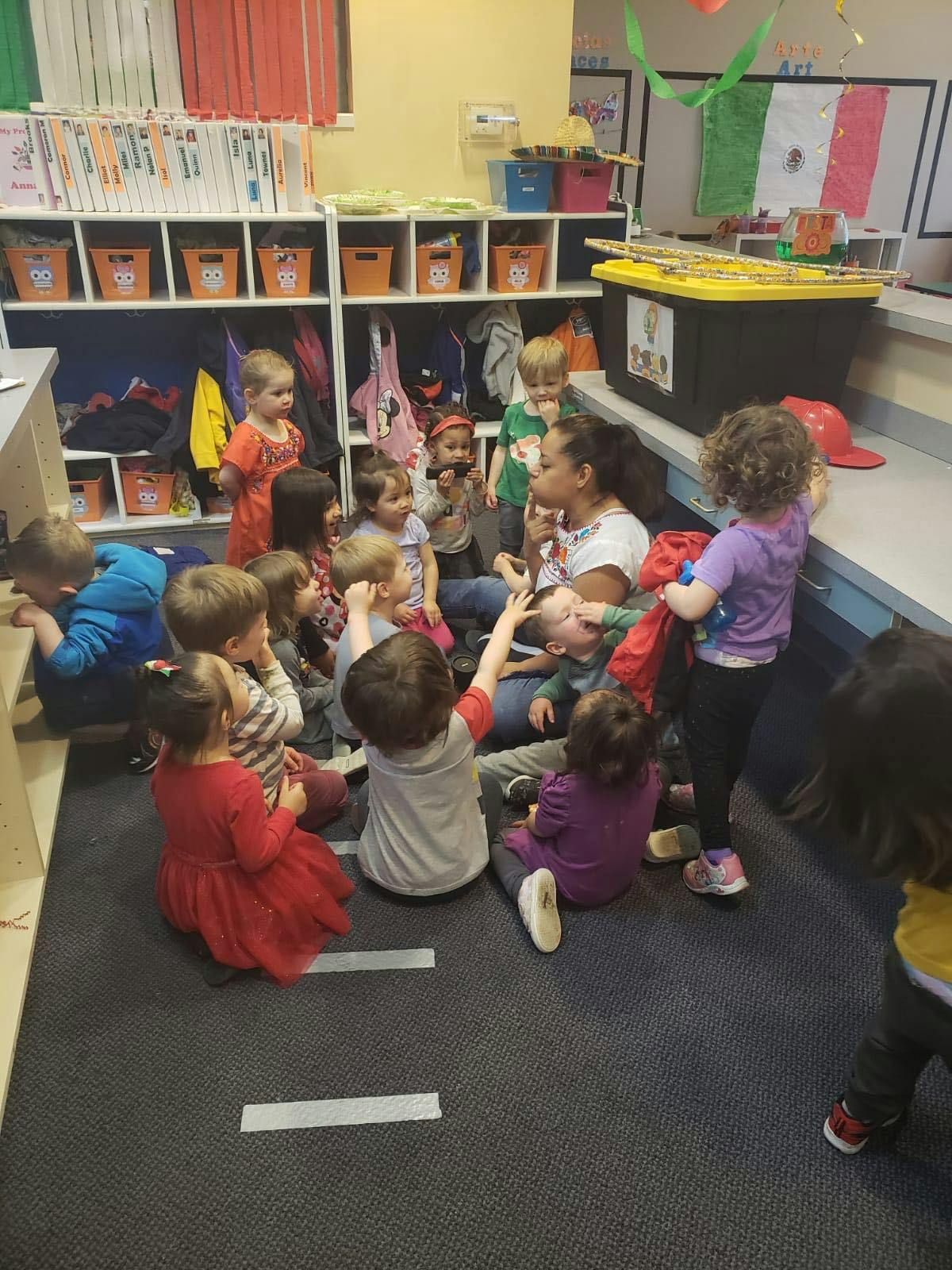 Adult and children sitting on floor in a classroom