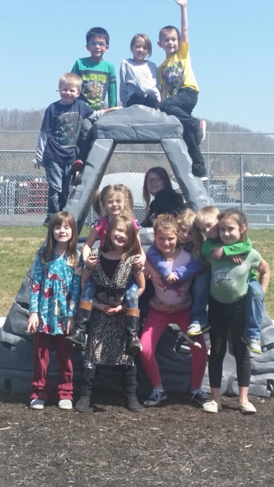 Group of children posing on and around a playground structure