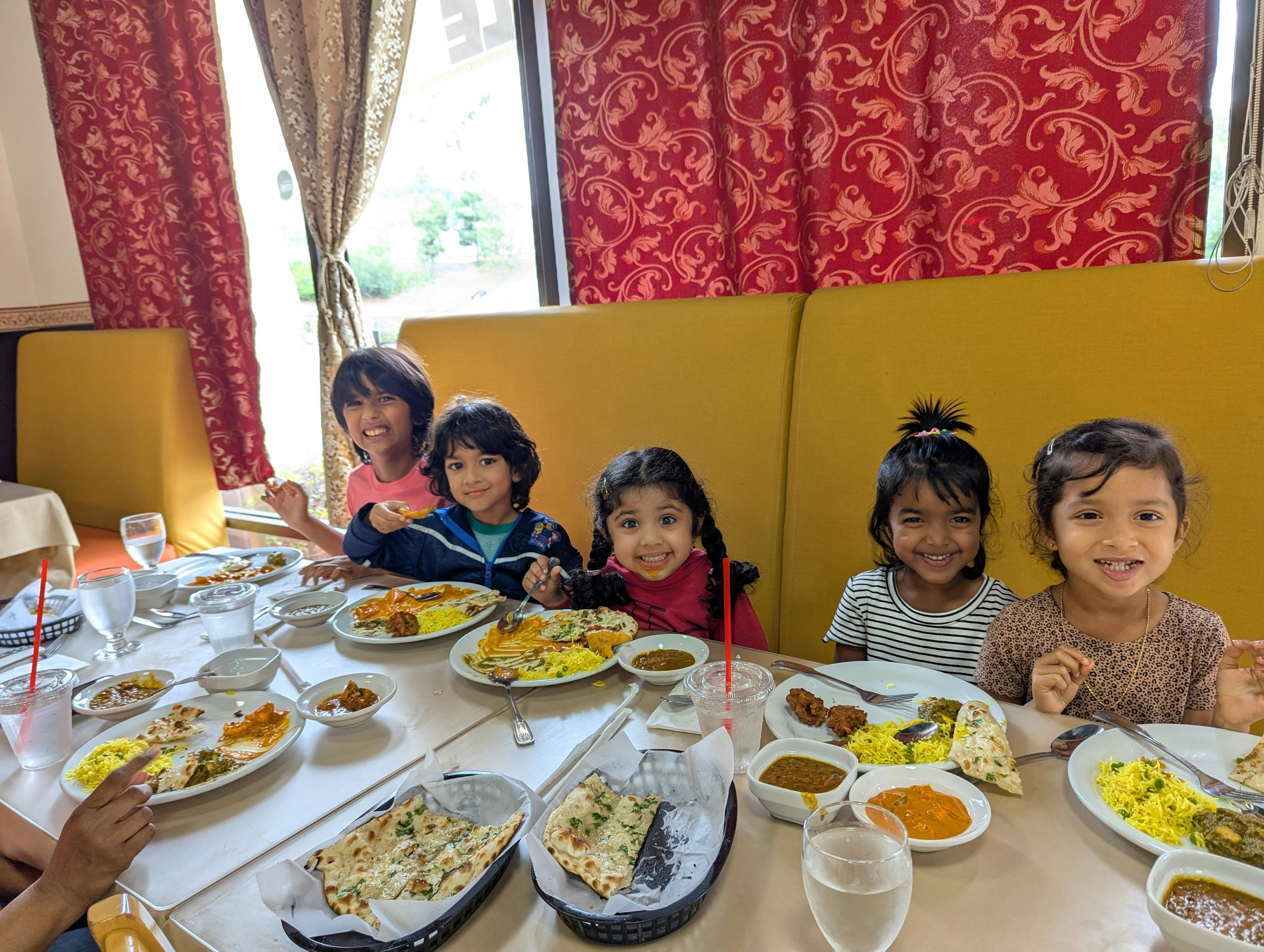 Children sitting at a table with plates of food