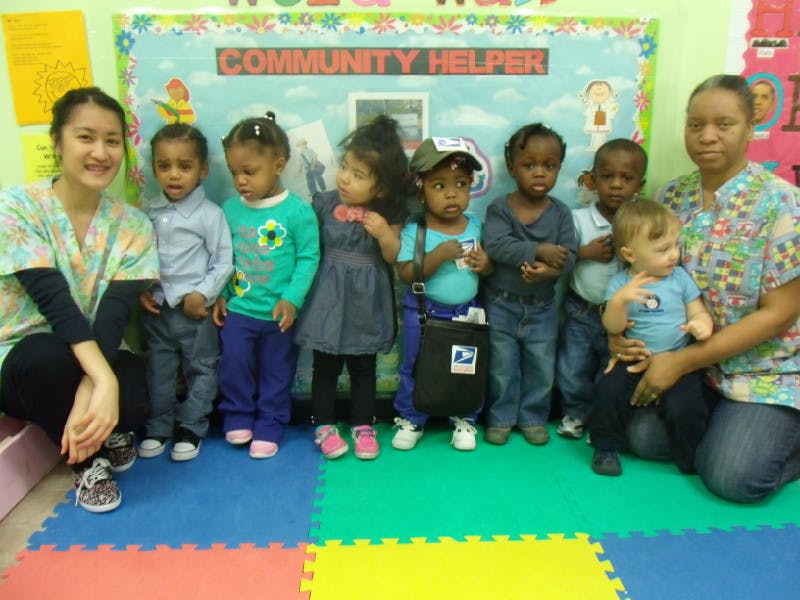Two adults with a group of children in a classroom