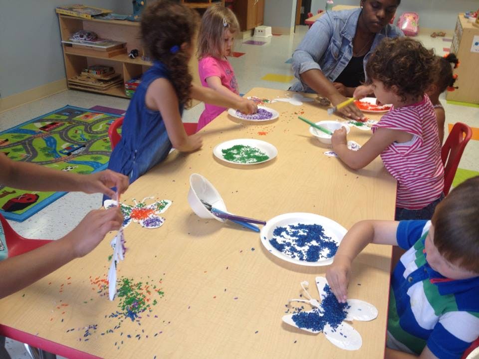 Children and an adult doing crafts at a table