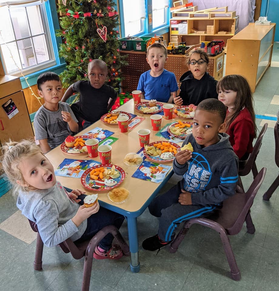 Children eating at a table in a classroom