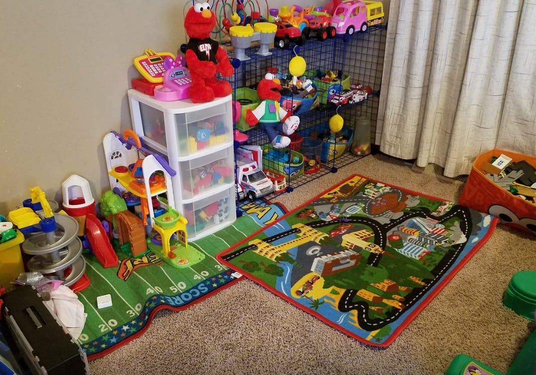 Playroom with various toys, storage, and two playmats on the floor